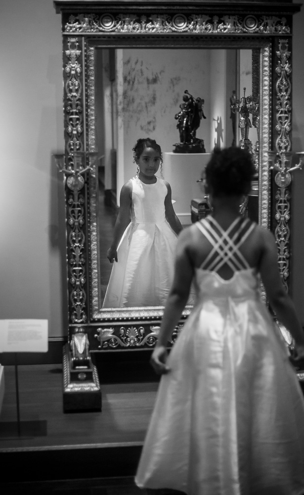 Black and white photo of girl in front of a mirror in NYC
