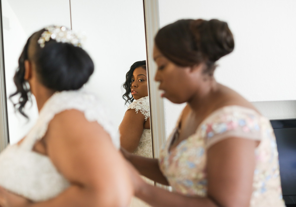 bride getting into her wedding dress with mom before her  new haven wedding 