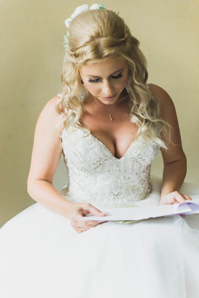 Bride reading letter from groom before woodwinds connecticut wedding