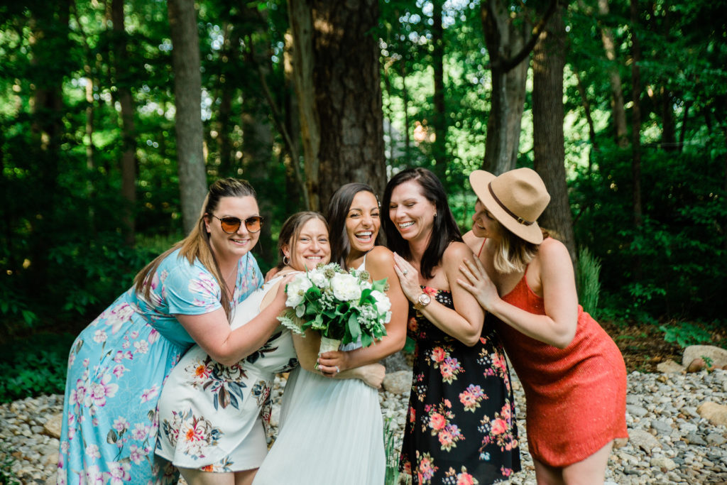Bride laughing with friends at her New england backyard wedding 