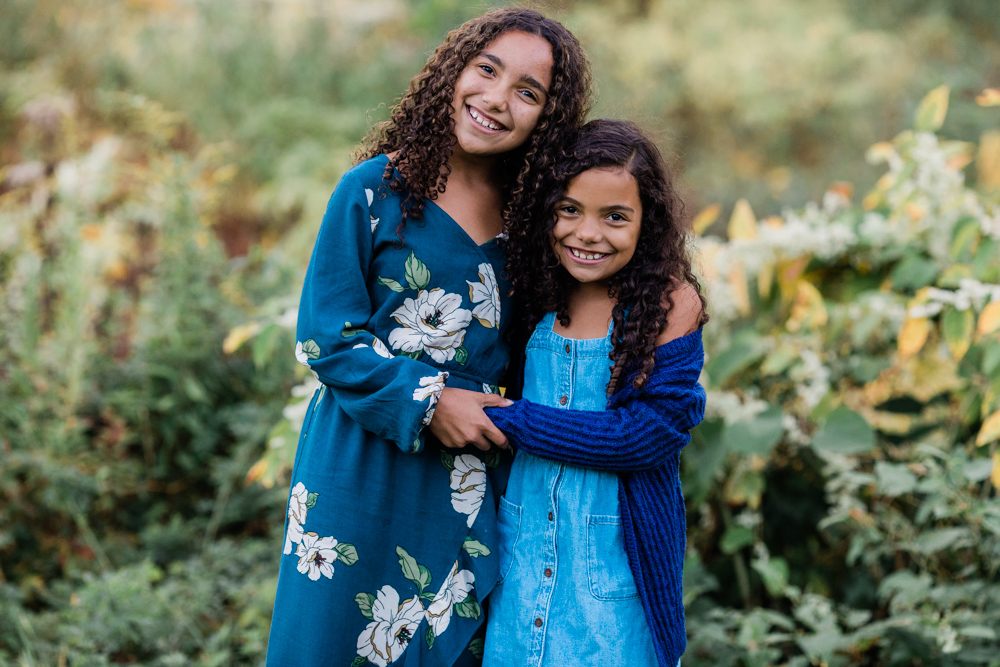sisters smiling at their family session at hubbard park