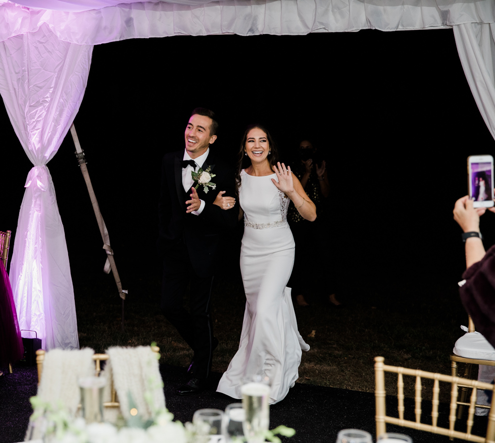 bride and groom enter the reception at their hillstead museum backyard wedding 