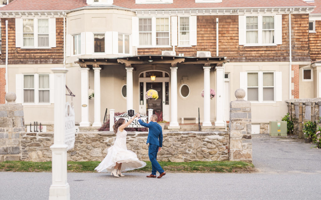bride and groom dancing in front of their venue of their fall mansion wedding
