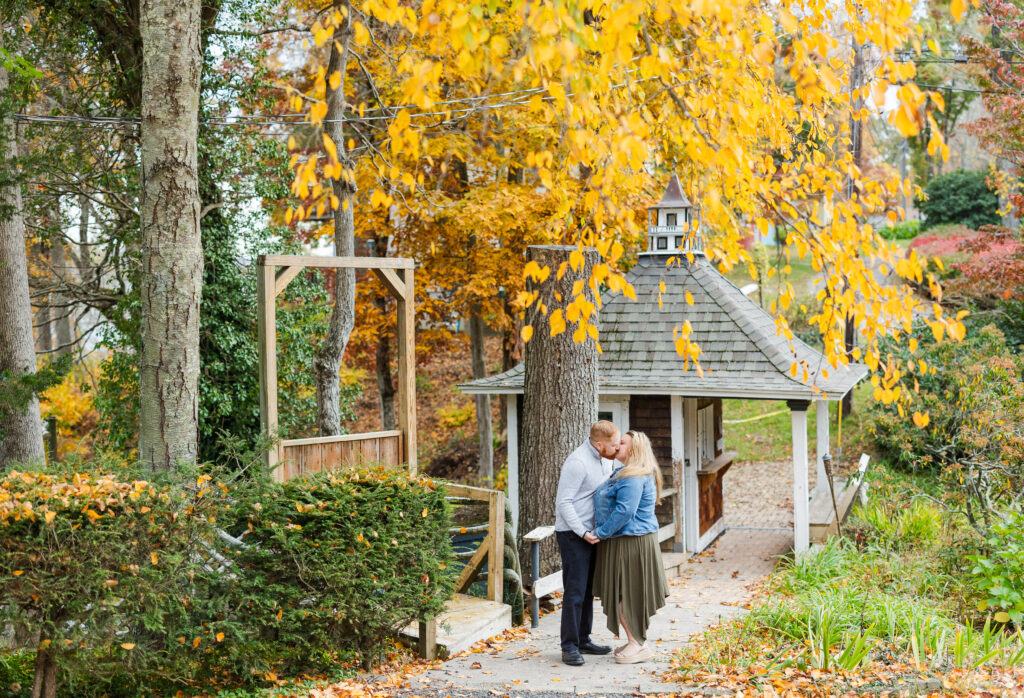 a couple kissing under a tree at their fall haddam engagement session